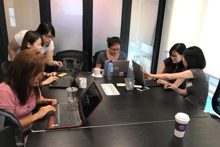 A team working together around a meeting room table at Sandbox Space