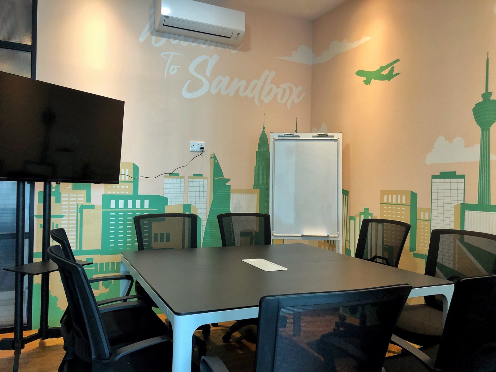 Meeting room for rent by the hour at Sandbox Space Sri Petaling with whiteboard, screen and KL skyline mural