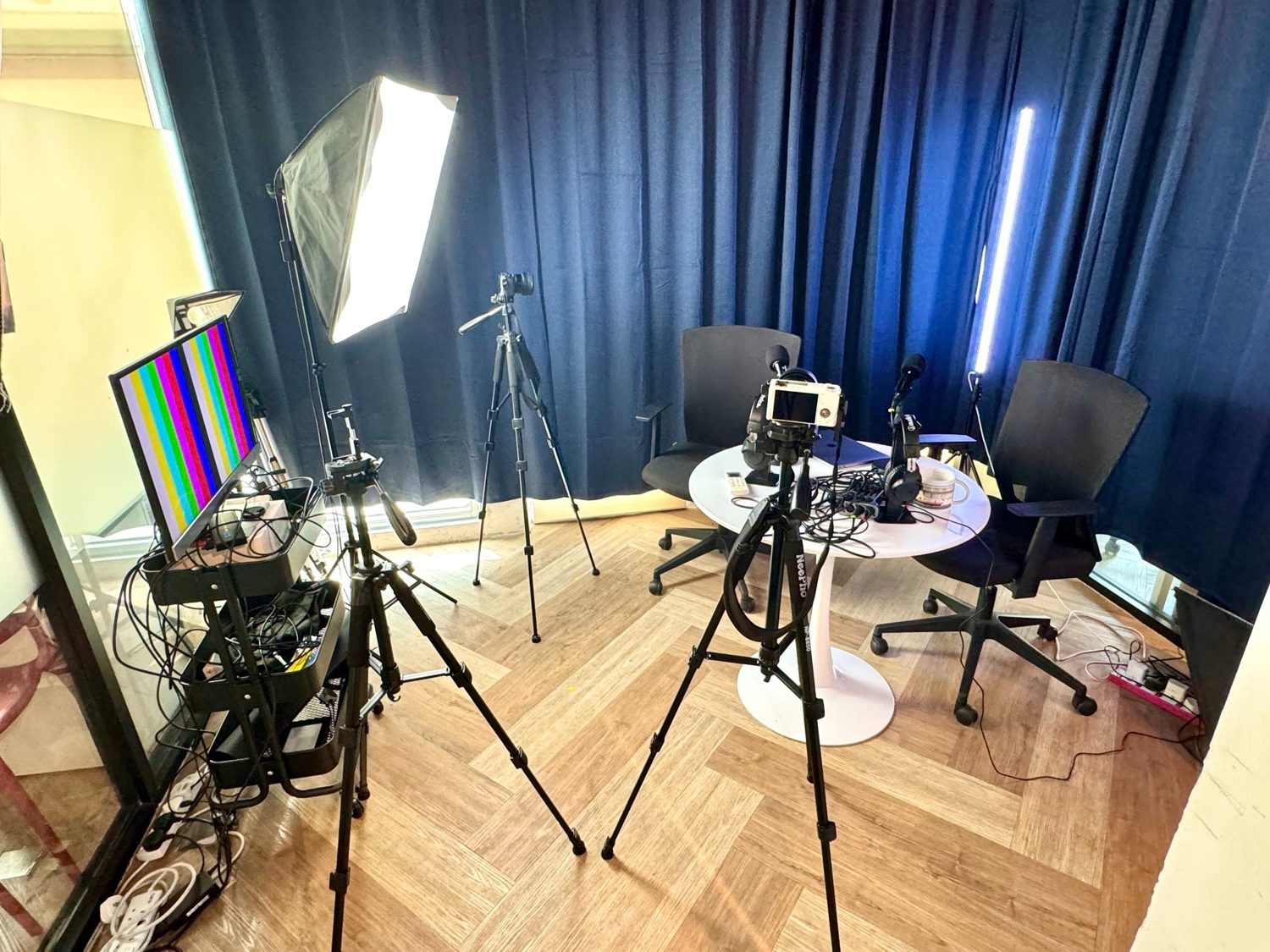 Podcast room setup with softbox lighting, tripods and live feed TV at Sandbox Space